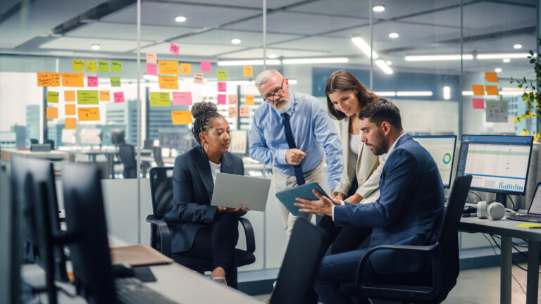 In Modern Office: Diverse Team of Managers Use Laptop and Tablet Computers at a Company Meeting Discussing Business Projects Young, Motivated and Experienced Employees Brainstorm in Conference Room