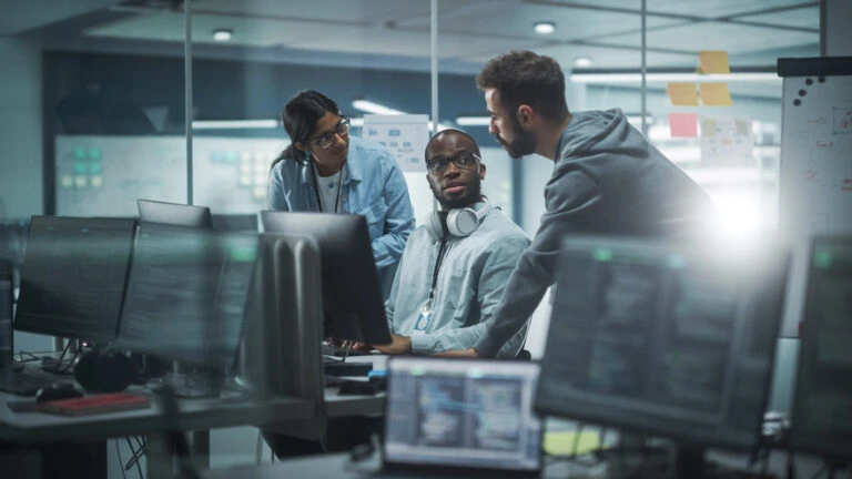 Diverse Group of Professionals Meeting in Modern Office: Brainstorming IT Programmers Use Computer Together, Talk Strategy, Discuss Planning Software Engineers Develop Inspirational App Program