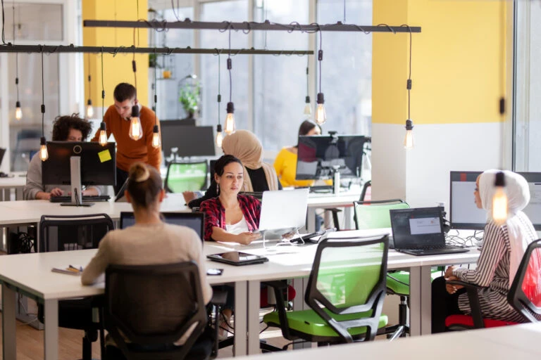 Creative team of young individuals working on desktop computers in a modern office space